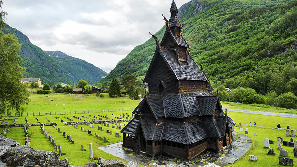 L'impressionnante église en bois debout de Borgund (stavkirke) avec son cimetière, nichée dans une vallée verdoyante de Norvège.